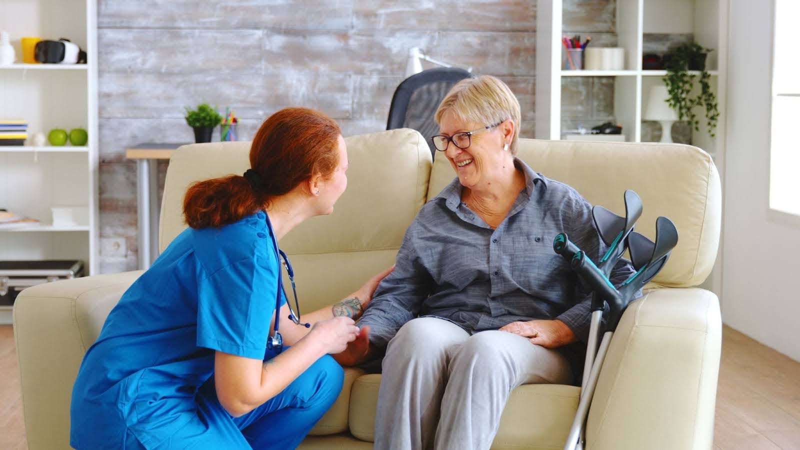 Bethanie's health care nurse assisting elderly patient while sitting down.