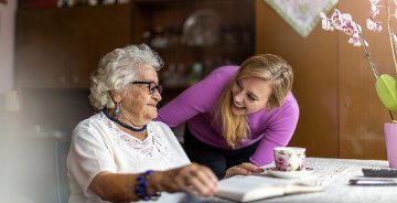 Young woman spending time with her elderly grandmother at home