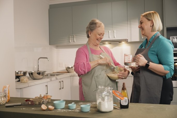 Elderly woman preparing cakes with staff
